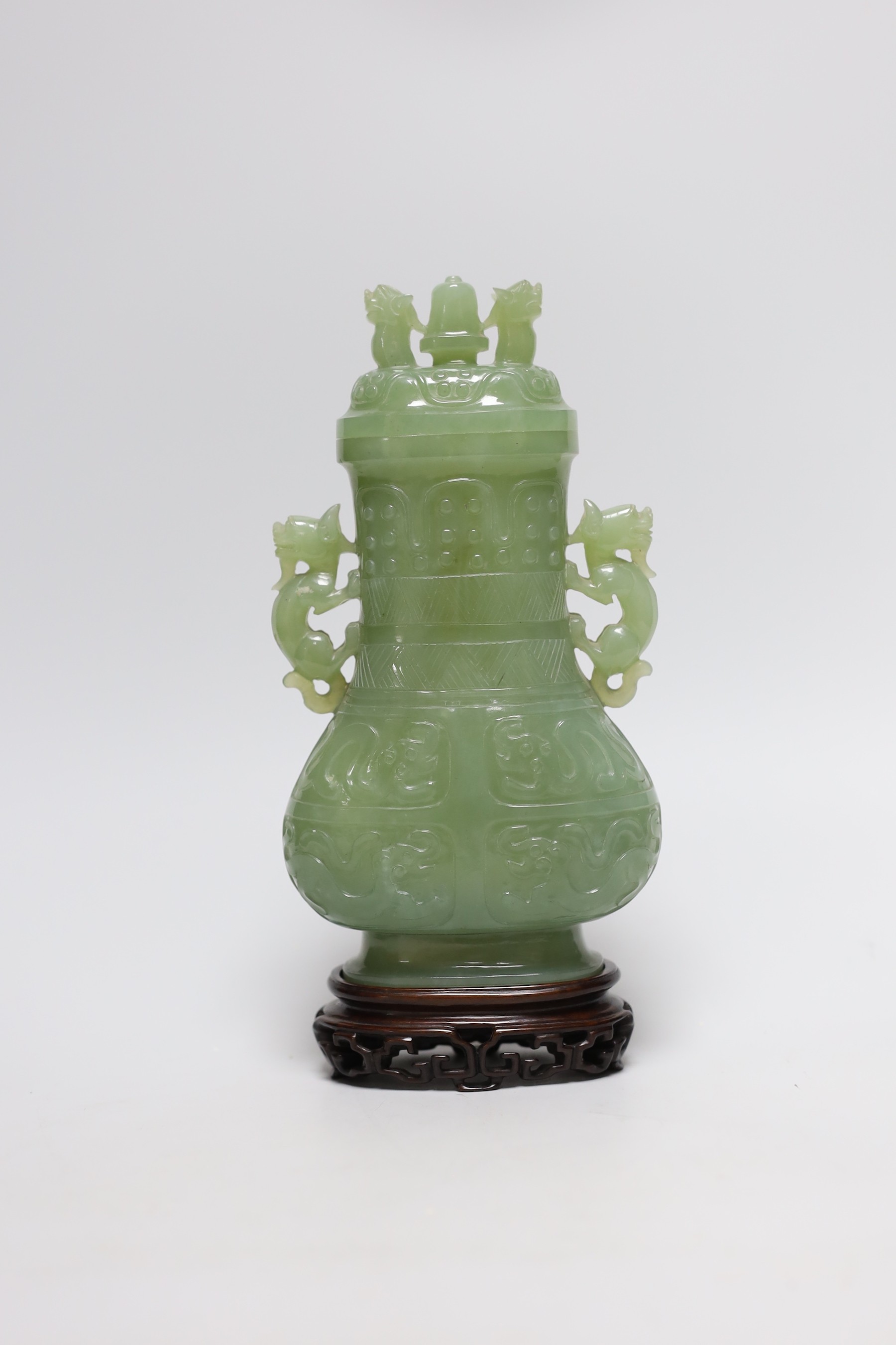 A Chinese carved bowenite jade vase and cover on hardwood stand, 23cm, with fitted case